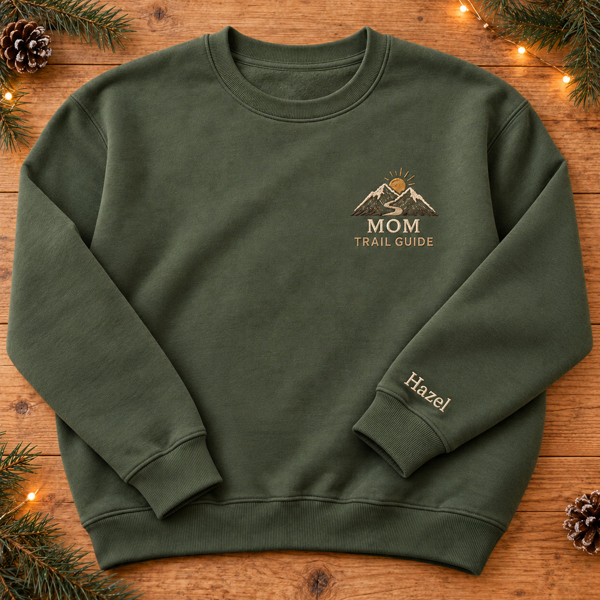 Mom's Adventure Trail sweatshirt concept mockup featuring mountains, a winding trail and a rising sun, sample personalization Hazel, hero view