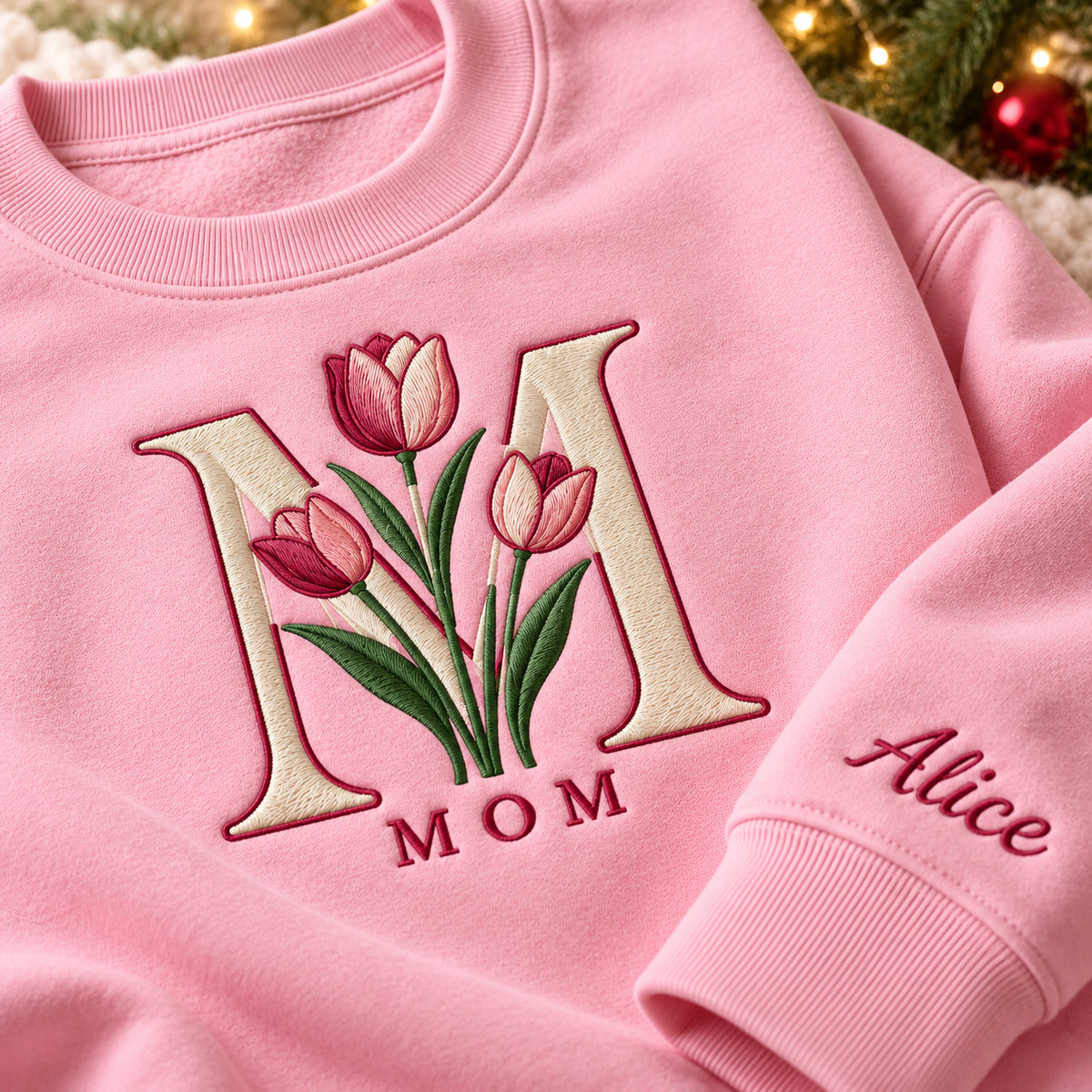 Mom's Tulip sweatshirt concept mockup featuring tulips framed by a large letter M, sample personalization Alice, embroidery view