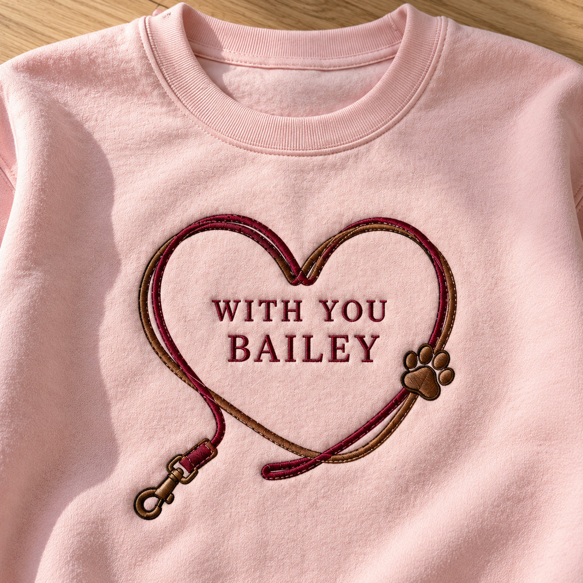Heart Leash sweatshirt concept mockup featuring a pet leash forming a heart around personalized lettering, sample personalization BAILEY, embroidery view