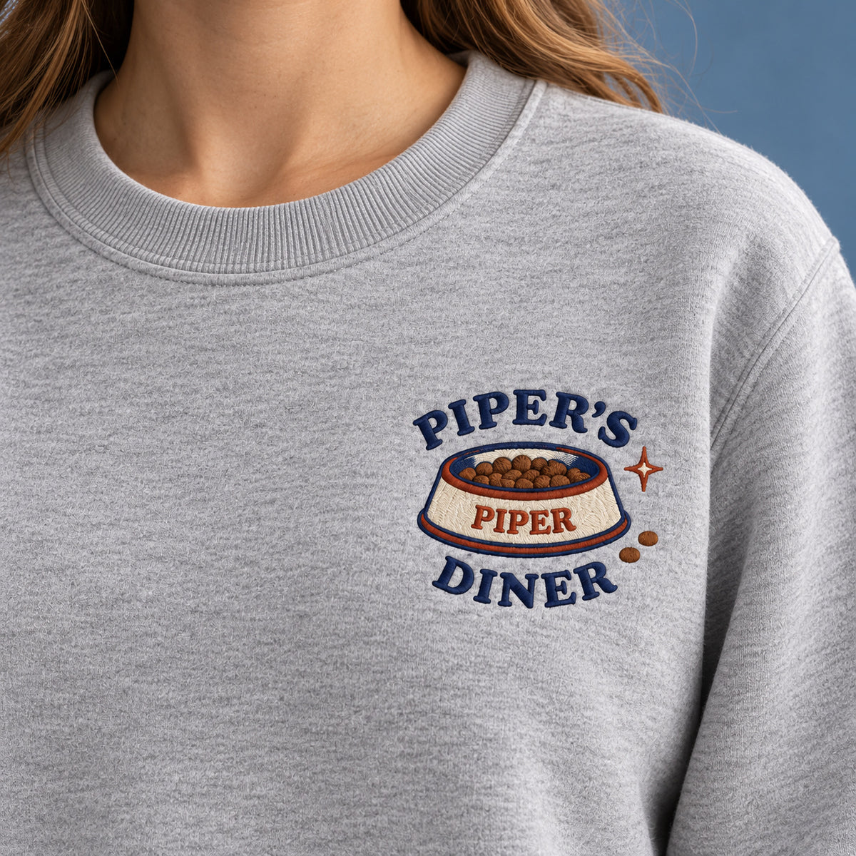 Pet Diner sweatshirt concept mockup featuring a personalized pet food bowl with diner lettering, sample personalization PIPER, embroidery view