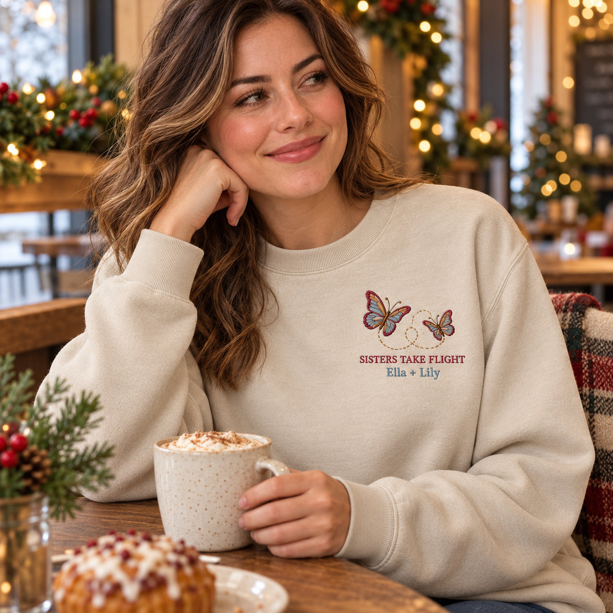 Sisters Take Flight sweatshirt concept mockup featuring two butterflies with a looping flight path, sample personalization Ella + Lily, lifestyle view